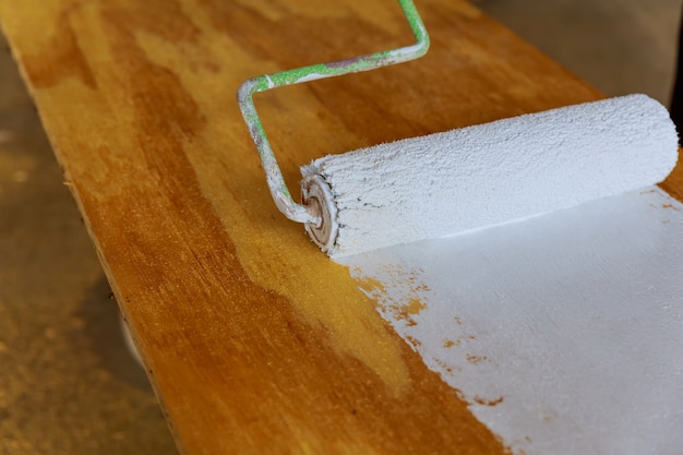 Photo painting the wood with white paint roller