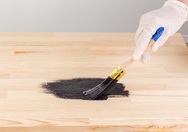 Painting wooden background hand with brush and can of paint