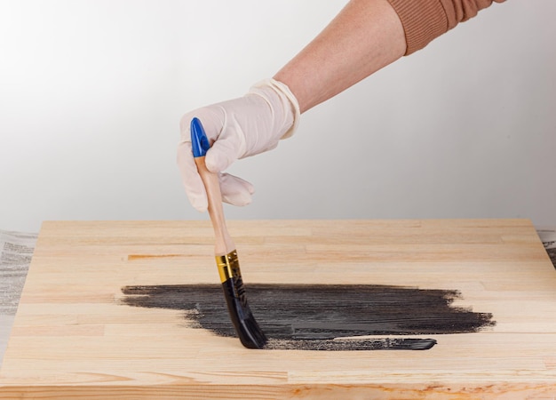 Painting wooden background hand with brush and can of paint