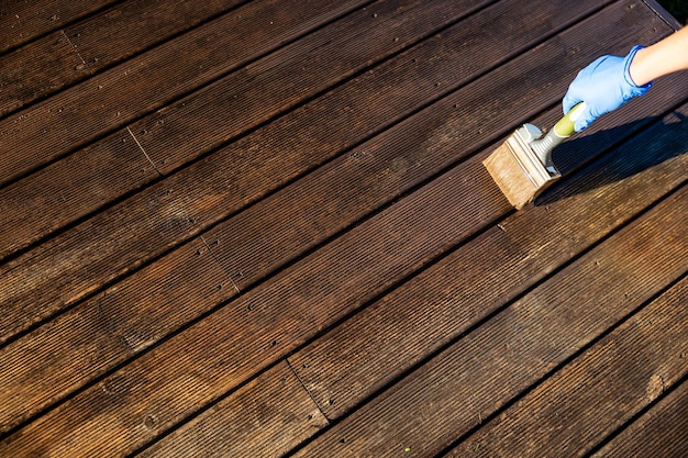 Photo painting the wooden flooring of a terrace