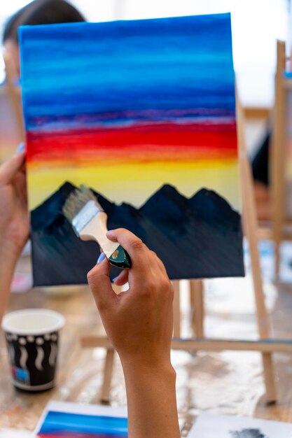 Photo painting workshop closeup of a young girl's hand painting