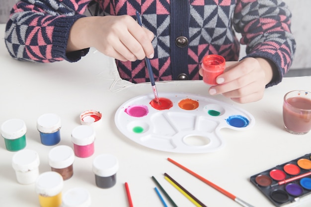 Paints on the desk. Painter holding brush. Work, Lifestyle