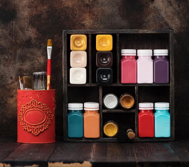 Paints for painting on a wooden shelf and brush. Set for drawing and creativity