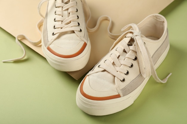 Pair of beige sneakers on two tone background