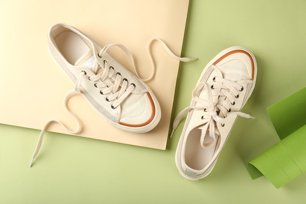 Pair of beige sneakers on two tone background