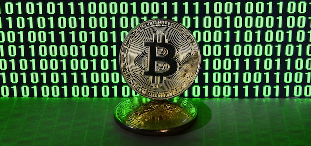 A pair of bitcoins lies on a cardboard surface on the background 