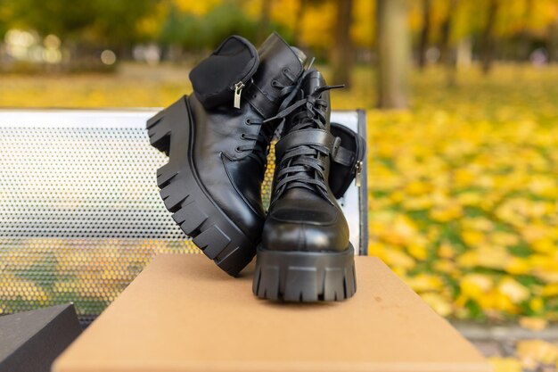 A pair of black boots are on a table in a park.