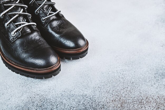 Pair of black genuine leather boots. Light background