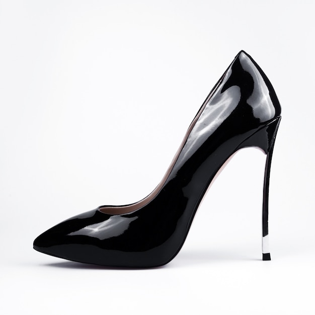 Pair of black patent leather female shoes on white