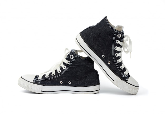 Pair of black textile sneakers with white laces isolated