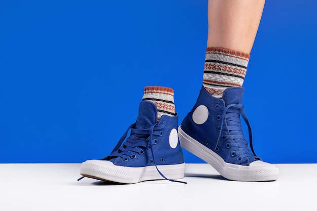 A pair of blue gym shoes, connected by laces