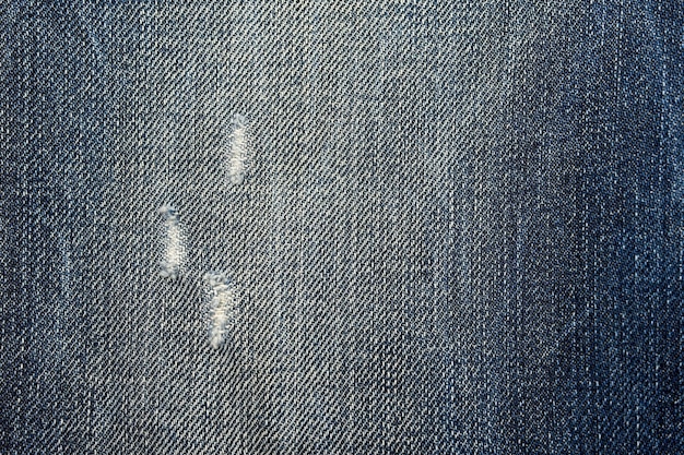 A pair of blue jeans with a hole in the middle.