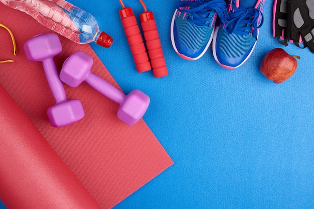 pair of blue training sneakers with laces, bottle of water