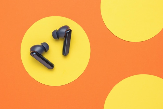 A pair of blue wireless headphones on a yelloworange background A popular wireless gadget