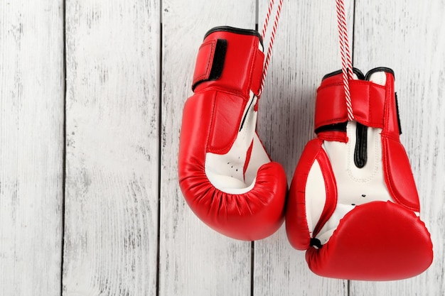 Pair of boxing gloves on color wooden background