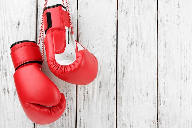 Pair of boxing gloves on color wooden background