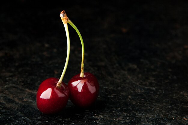 Pair of cherries on black background