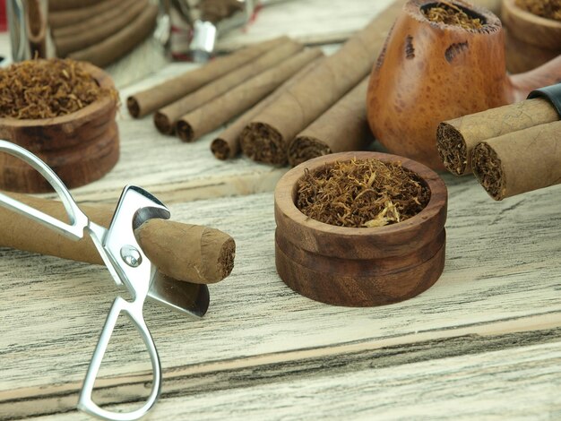 Photo a pair of cigars sit on a wooden table with a pair of scissors.