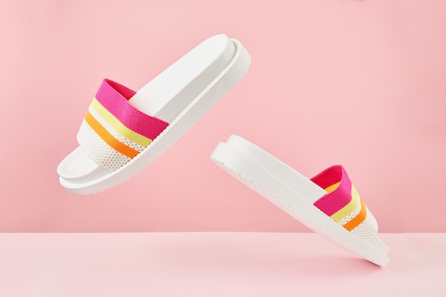 Pair of colorful multicolored rainbow flip flops or sandals on pastel background Summer concept