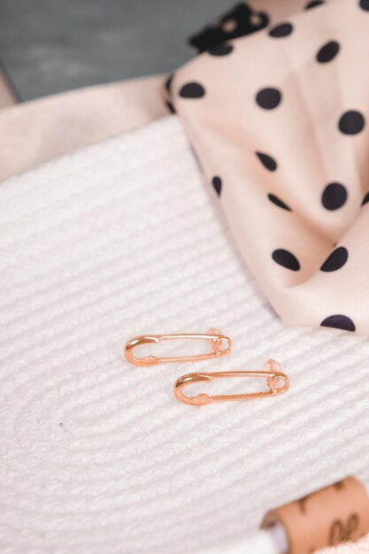 A pair of copper paper clips sit on a white surface.