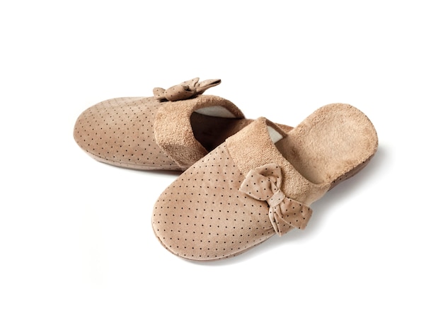 Pair of cozy beige house slippers with bows isolated