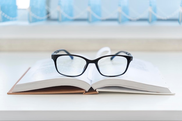 Pair of designer glasses on an opened book