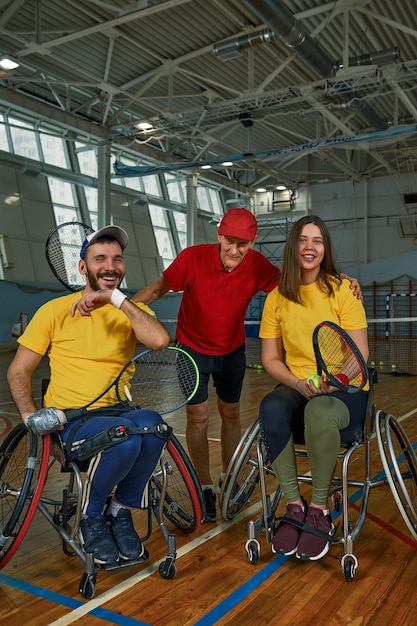 Photo pair of disabled tennis players hugging each other with their master