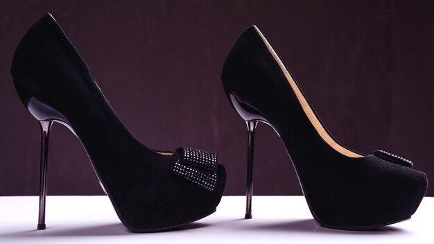 Pair of elegant high heel shoes on background