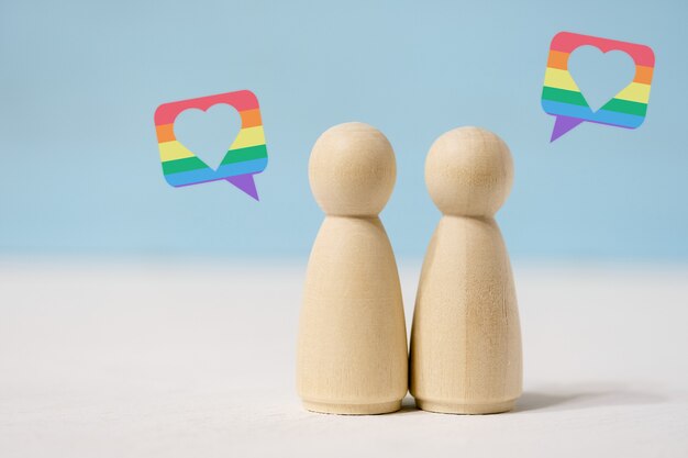 Photo pair of female wooden figures in love stand close together.