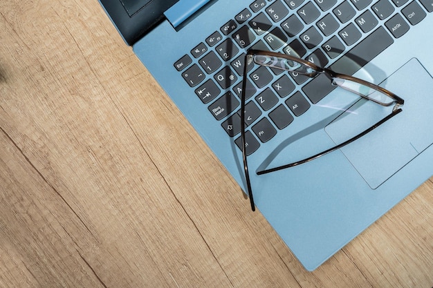 A pair of glasses on an open laptop keyboard and room for text. Technology, health concept.