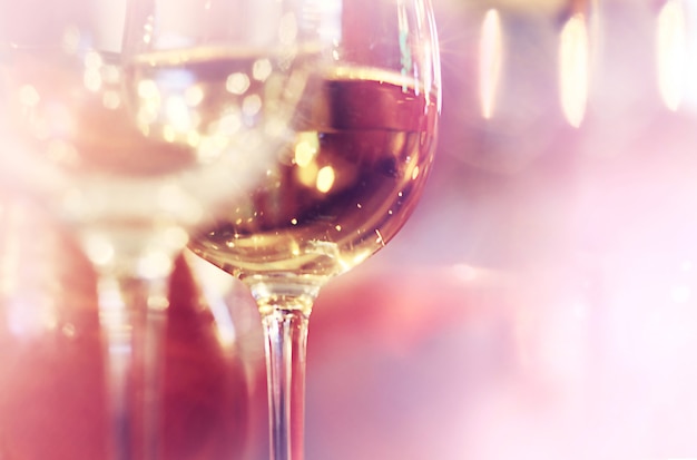 A pair glasses of wine on light bokeh background with copy space for text. Party theme.