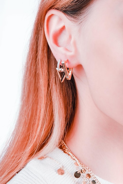 A pair of gold earrings with a gold chain and a bow.