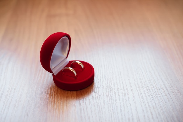 Pair of gold wedding rings lie in a red box