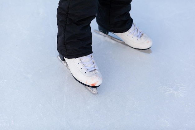 A pair of hockey skates with laces on frozen ice rink closeup. Ice skating or playing hockey