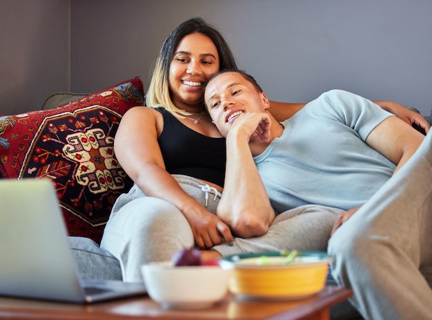 A pair of home bodies Shot of a couple watching a video on a laptop at home