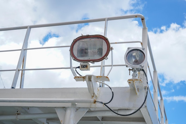 A pair of lights on a boat are mounted on the railing.