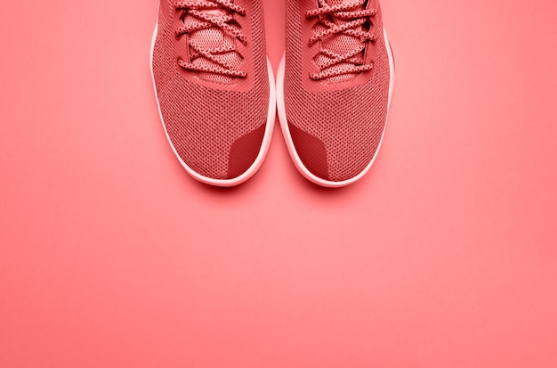 Pair of living coral sport shoes on background