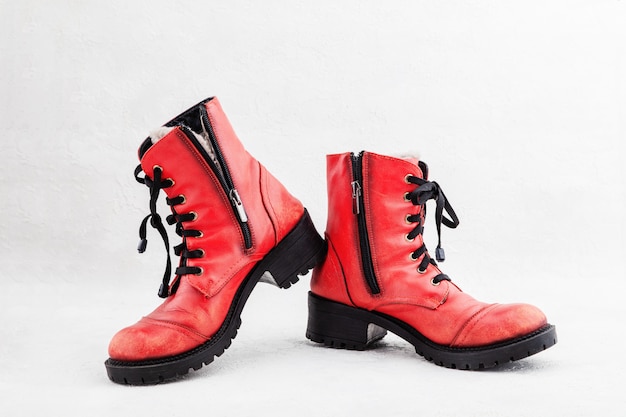 Pair of old leather red discarded boots with laces