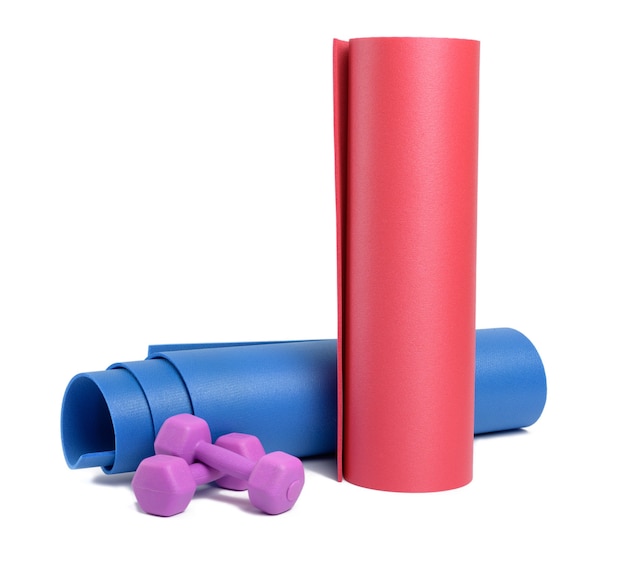 Pair of plastic kg dumbbells and yoga mat isolated on white surface