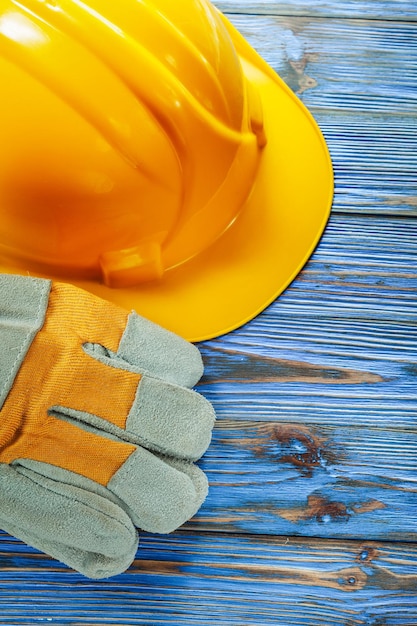 Pair of protective gloves hard hat on vintage wooden board