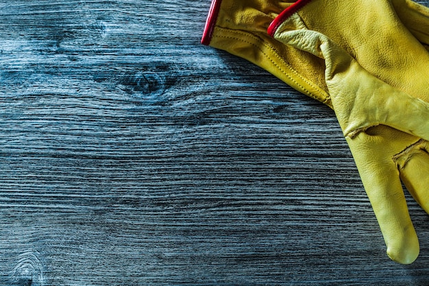 Pair of protective gloves on wooden board