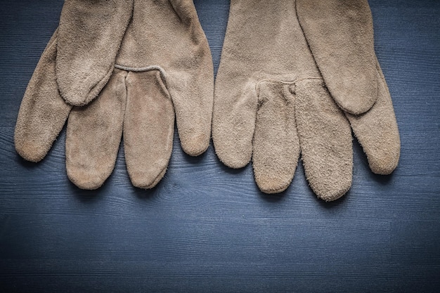 Pair of protective working gloves on wooden board