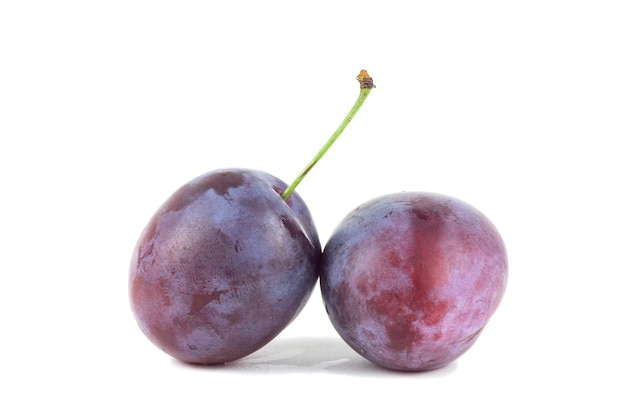 Photo pair of purple plums with leaf isolated on white background