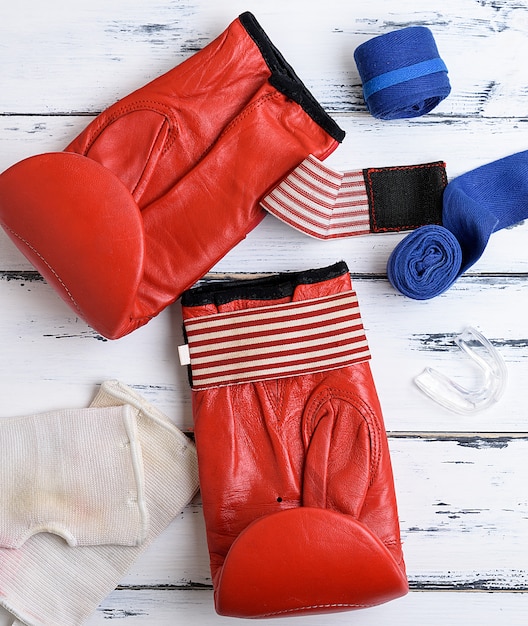 Photo pair of red leather boxing gloves, blue textile bandage