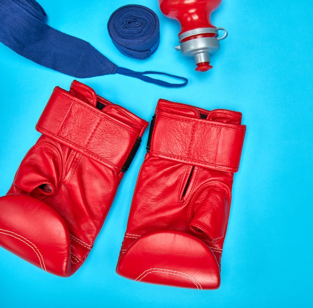 Photo pair of red leather boxing gloves and a textile bandage