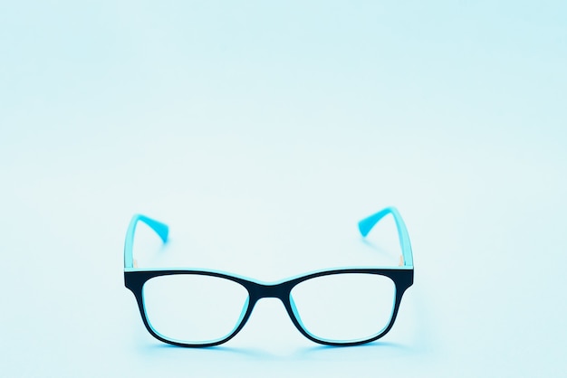 Pair of red plastic-rimmed eyeglasses on a blue background