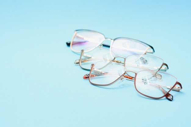 Pair of red plastic-rimmed eyeglasses on a blue background