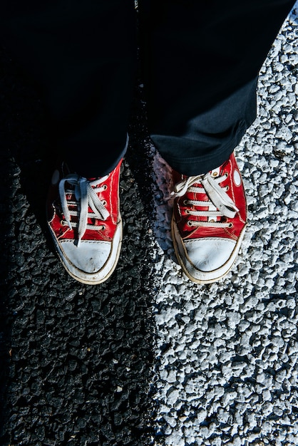 Pair red shoe on the pavement. Black asphalt texture