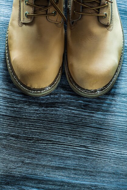 Pair of safety boots on wooden board