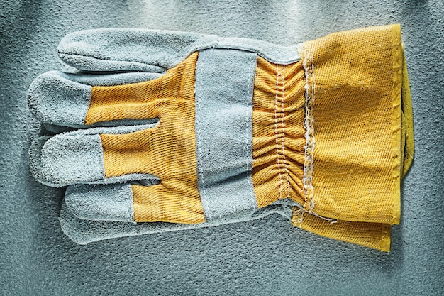 Pair of safety gloves on concrete background